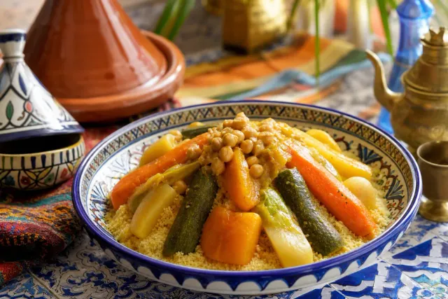 Mound of Moroccan seven-vegetable couscous topped with carrots, squash and chickpeas